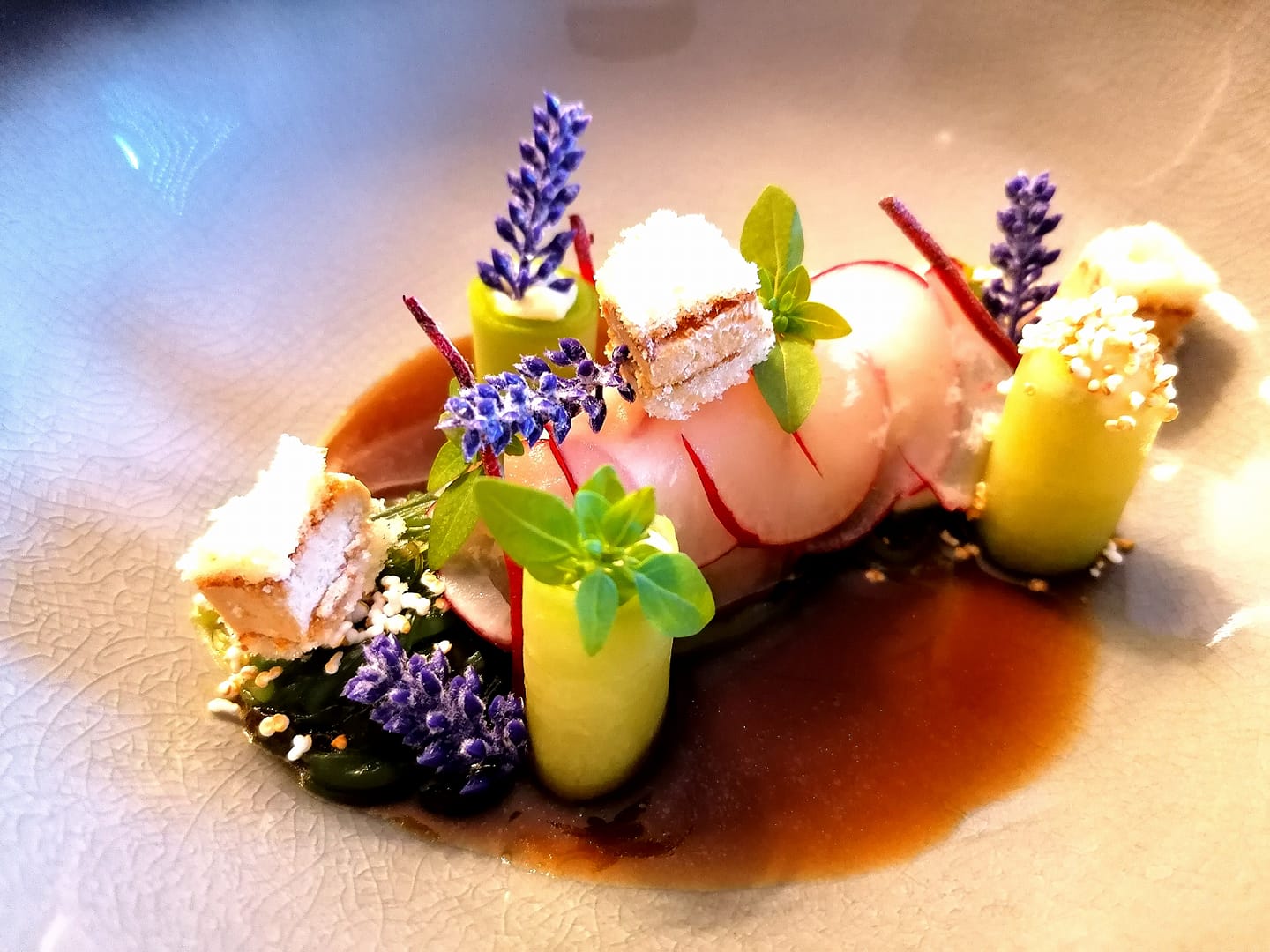 Kunstvoll angerichteter Fisch mit Lavendelblüten und Gurke